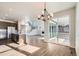 Open-concept living room with modern chandelier, stainless steel appliances, and large sliding doors to a patio at 2690 E 102Nd Pl, Thornton, CO 80229