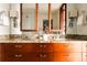 Elegant bathroom featuring granite countertops, wood cabinets, and dual sinks with large mirrors at 1133 14Th St # 3420, Denver, CO 80202