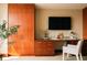Bedroom office area with wood wardrobe, modern desk, and wall-mounted TV at 1133 14Th St # 3420, Denver, CO 80202