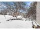 Snowy backyard with a large tree, bushes, and a patio area, offering a tranquil outdoor space at 2141 S Victor St # B, Aurora, CO 80014
