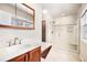 Bright bathroom featuring a glass enclosed shower, a bench, tile floors, and a wood vanity with marble countertop at 2141 S Victor St # B, Aurora, CO 80014