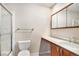Bathroom featuring a vanity with a sink, toilet, and a glass-enclosed shower at 2141 S Victor St # B, Aurora, CO 80014