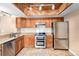 Modern kitchen featuring stainless steel appliances, ample cabinet space, and tiled floors under a stunning wood-trimmed ceiling at 2141 S Victor St # B, Aurora, CO 80014