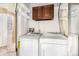 Functional laundry room with modern appliances, including a washer and dryer, and built-in shelving for convenient storage at 2141 S Victor St # B, Aurora, CO 80014