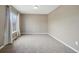 A neutral carpeted bedroom with natural lighting from large windows and light colored walls at 12248 Kittredge St, Commerce City, CO 80603