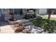 Landscaped front yard featuring flower beds, green lawn, stone accents, and concrete steps leading to the covered porch at 12248 Kittredge St, Commerce City, CO 80603
