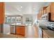 Modern kitchen with stainless steel appliances, a center island, and open access to the living area at 12248 Kittredge St, Commerce City, CO 80603