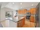 Bright kitchen featuring stainless steel appliances, a center island with a sink, and a sliding glass door to the deck at 12248 Kittredge St, Commerce City, CO 80603