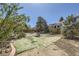 This large backyard features a turf area and is surrounded by mature trees and shrubs at 14742 E Radcliff Pl, Aurora, CO 80015