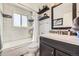 Clean bathroom features a shower-tub combo with shelf and a sleek vanity with mirror at 14742 E Radcliff Pl, Aurora, CO 80015