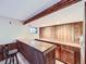 Basement bar featuring wood paneling, a sink, countertop, and a unique wood beam ceiling detail at 1467 S Kenton St, Aurora, CO 80012