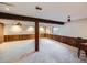 Carpeted basement area with wood paneling, exposed beams, and a window for natural light at 1467 S Kenton St, Aurora, CO 80012