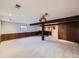 Spacious basement featuring carpet, wood paneling, exposed beams, and a view of the basement bar at 1467 S Kenton St, Aurora, CO 80012