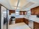 Well-lit kitchen with stainless steel appliances, wood cabinets, and tile flooring at 1467 S Kenton St, Aurora, CO 80012