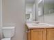 Clean bathroom with wood vanity, single sink, and a toilet at 1267 Bluejay Ave, Brighton, CO 80601