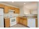 Well-equipped kitchen featuring wood cabinets, tile flooring, and modern appliances at 1267 Bluejay Ave, Brighton, CO 80601