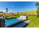 Landscaped backyard with a large hot tub and sprawling green lawn, perfect for relaxing and entertaining at 15647 Weaver Gulch Dr, Morrison, CO 80465