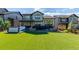 A spacious backyard with a hot tub, stone patio, and lush artificial turf for easy maintenance at 15647 Weaver Gulch Dr, Morrison, CO 80465