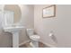 This powder bath features a pedestal sink, a decorative mirror, and neutral wall paint at 15647 Weaver Gulch Dr, Morrison, CO 80465
