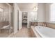 This bathroom includes a soaking tub, glass shower, and a view into the Primary bedroom at 15647 Weaver Gulch Dr, Morrison, CO 80465