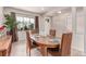 Bright dining room featuring an oval wood table, seating for four, and a large window at 15647 Weaver Gulch Dr, Morrison, CO 80465