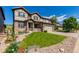 Inviting two-story home with stone accents, a well-manicured lawn, and an attached garage at 15647 Weaver Gulch Dr, Morrison, CO 80465