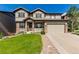 Beautiful two-story home with stone accents, a well-manicured lawn, and an attached two-car garage at 15647 Weaver Gulch Dr, Morrison, CO 80465