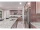 This kitchen features stainless steel appliances, a large granite island and dark wood cabinets at 15647 Weaver Gulch Dr, Morrison, CO 80465