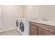 Practical laundry room featuring sink, ample counter space, and modern washer and dryer at 15647 Weaver Gulch Dr, Morrison, CO 80465
