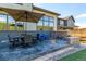 Backyard with patio including a stone fire pit and an umbrella table set for dining and entertaining at 15647 Weaver Gulch Dr, Morrison, CO 80465