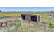 Brown metal barn with two stalls and fenced area at 45425 Wolf Creek Dr, Bennett, CO 80102