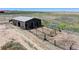 Aerial view of a metal barn with attached pens at 45425 Wolf Creek Dr, Bennett, CO 80102