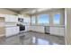 Basement kitchen with white cabinets, stainless steel appliances, and concrete floors at 45425 Wolf Creek Dr, Bennett, CO 80102