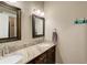 Bathroom with granite countertops, double sinks, and decorative mirrors at 45425 Wolf Creek Dr, Bennett, CO 80102