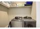 Bright laundry room with Samsung washer and dryer, and shelving for storage at 45425 Wolf Creek Dr, Bennett, CO 80102