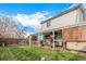 Large backyard featuring a covered patio, hot tub, lush lawn, and privacy fencing at 6119 Zenobia Ct, Arvada, CO 80003