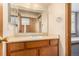 Bathroom with wood vanity, sink, and a mirrored medicine cabinet at 6119 Zenobia Ct, Arvada, CO 80003