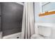 Updated bathroom with gray tiled shower and white toilet at 6119 Zenobia Ct, Arvada, CO 80003