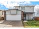 Two-story house with attached garage and rocking chair on porch at 6119 Zenobia Ct, Arvada, CO 80003