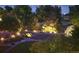Dusk aerial showcases the landscaped backyard with lush trees and landscape lighting at 9158 Forest St, Firestone, CO 80504