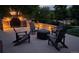 Inviting backyard patio area with built-in stone fireplace and comfortable Adirondack chairs at 9158 Forest St, Firestone, CO 80504