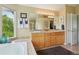 Primary bathroom with a double sink vanity, linen closet and view of mature trees at 9158 Forest St, Firestone, CO 80504