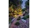 Outdoor gravel path is enhanced by landscape lighting at night, with shed in background at 9158 Forest St, Firestone, CO 80504