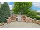 An outdoor stone kitchen features a stainless steel grill and bar seating area at 9158 Forest St, Firestone, CO 80504