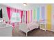 Bright bedroom featuring colorful striped walls, a white bed frame, and ample natural light at 3008 Echo Park Dr, Castle Rock, CO 80104