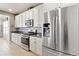 Well-lit kitchen featuring white cabinets, stainless steel appliances, and ample counter space at 3008 Echo Park Dr, Castle Rock, CO 80104