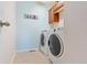 Bright laundry room with side-by-side washer and dryer and a wooden cabinet for storage at 3008 Echo Park Dr, Castle Rock, CO 80104