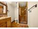 Bathroom featuring a tiled shower with glass door, as well as a sink with a decorative vanity at 17995 Minglewood Trl, Monument, CO 80132