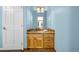 The bathroom has a light blue wall paint, and a single sink vanity that features a light oak finish at 17995 Minglewood Trl, Monument, CO 80132