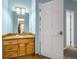 Bathroom with a single sink vanity and oak cabinets, with a view into the open closet at 17995 Minglewood Trl, Monument, CO 80132